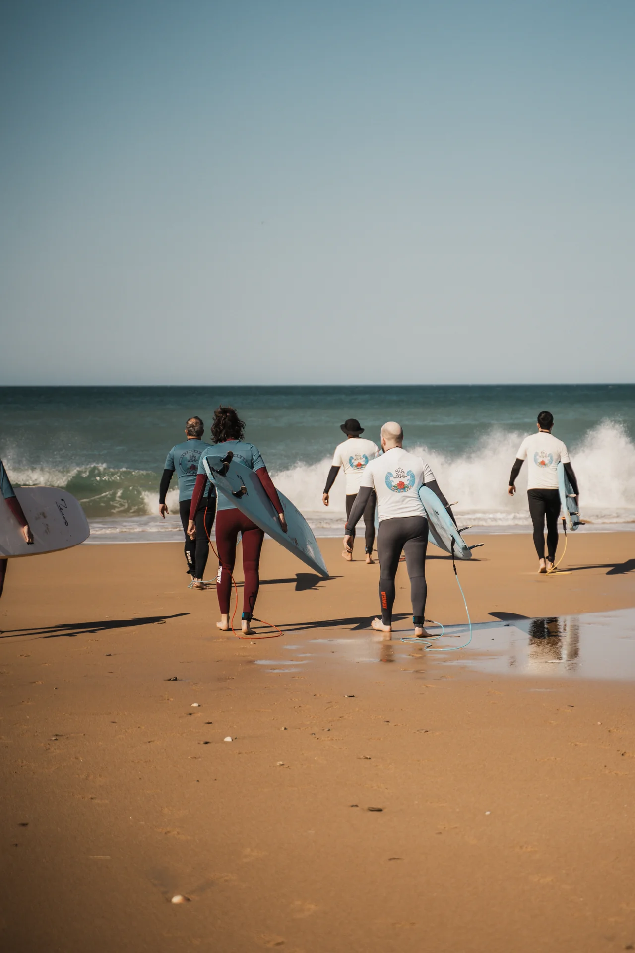 Alumnos con las camisetas de Big Wave entrando al mar en El Palmar