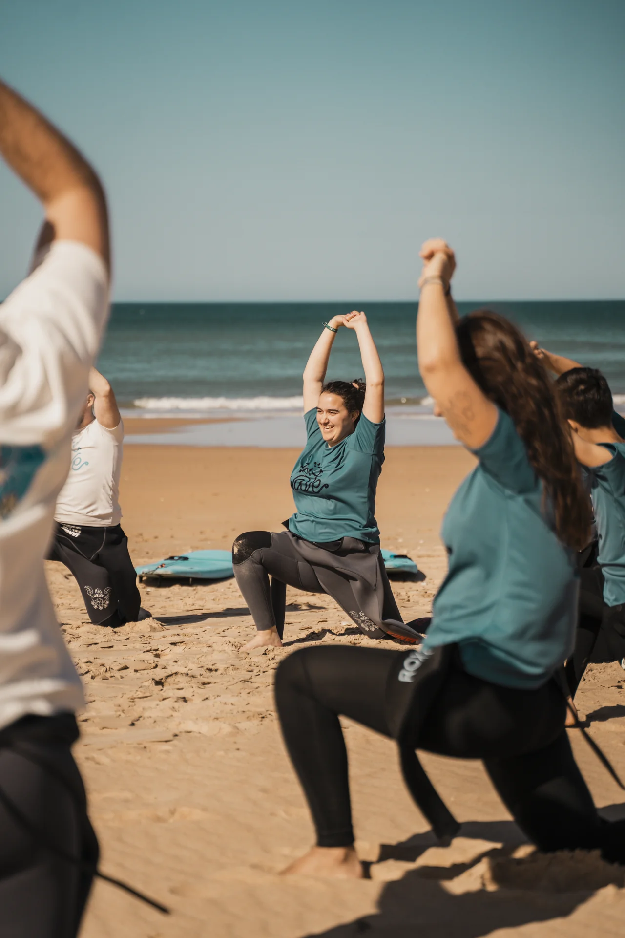 Alumnos con licras de Big Wave realizando el calentamiento antes de surfear