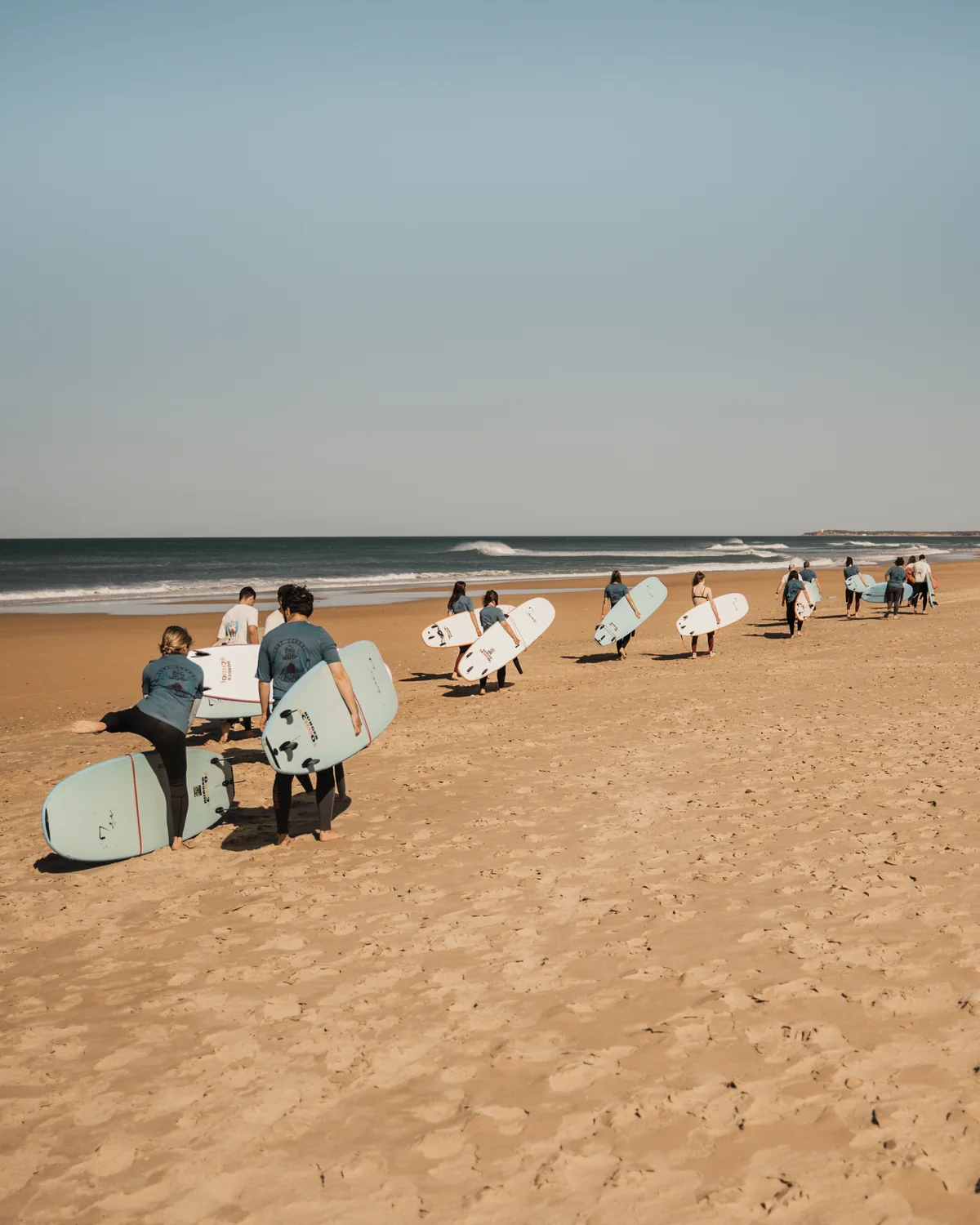 Grupo de Big Wave caminando con tablas por la playa de El Palmar