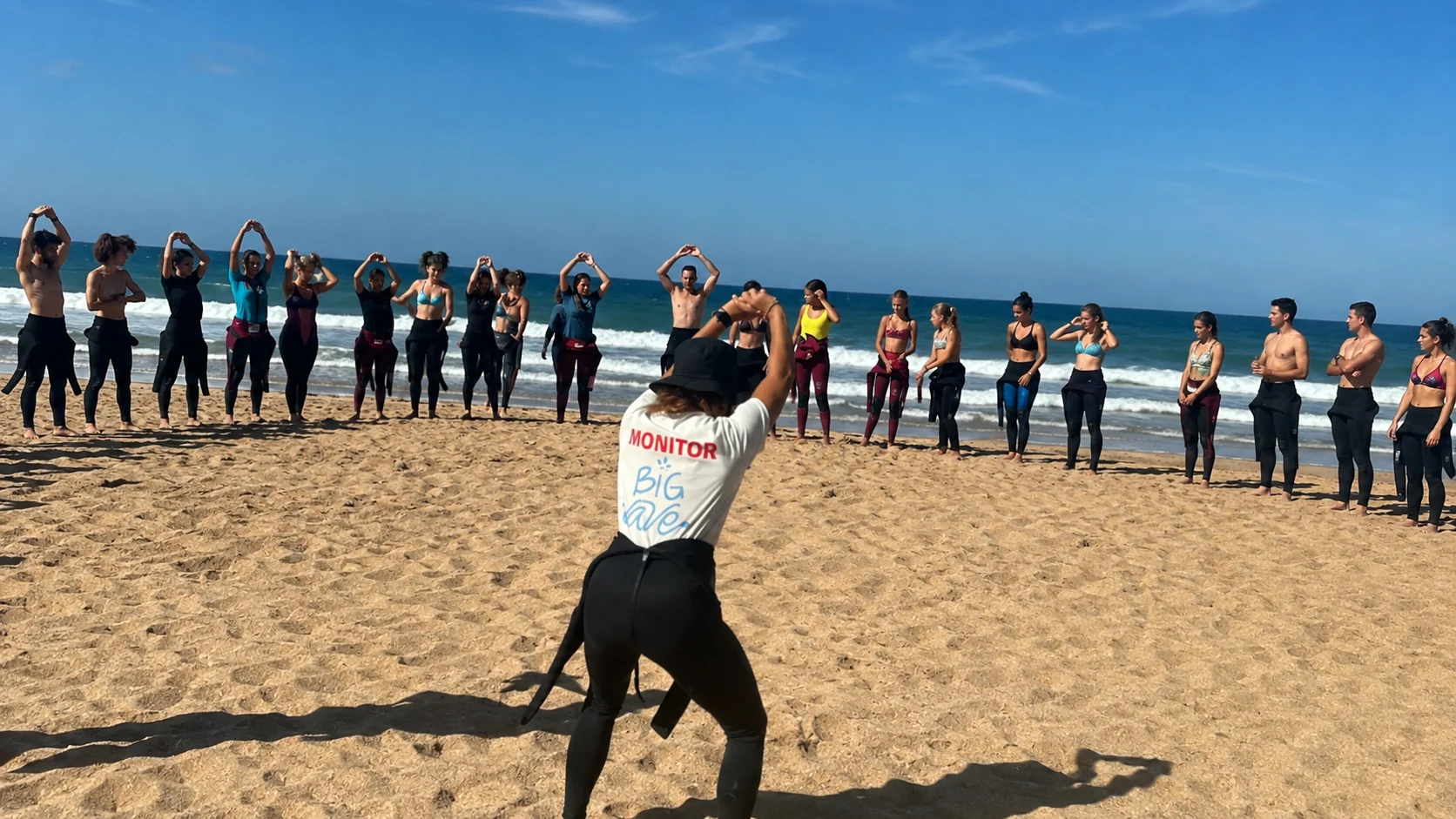 Grupo de alumnos de Big Wave calentando antes de una clase de surf en El Palmar